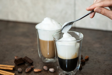Milk foam is put in a coffee.