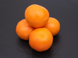 Sweet tangerines. Citrus fruits on dark background