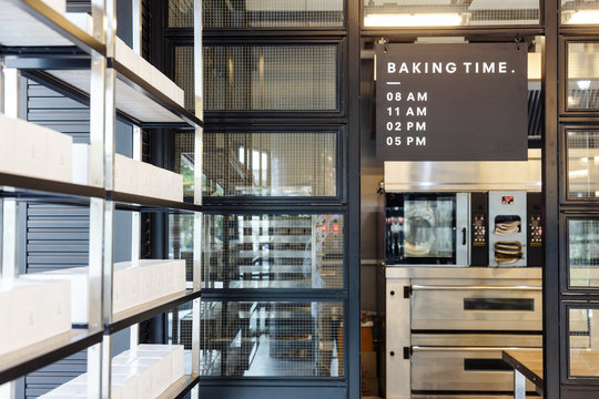 Modern pastry kitchen entrance decorated in black, white and steel with baking schedule board.