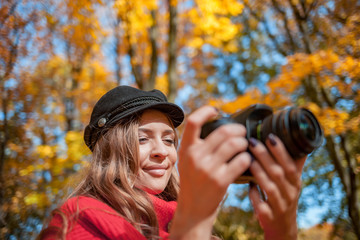 Young woman having fun with camera making photos at green park