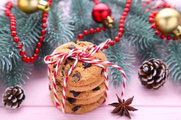 Chocolate cookies and christmas decoration on pink wooden background