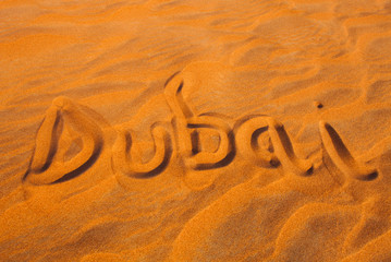 Dubai word in sand desert travel concept