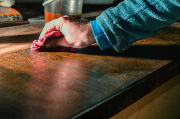 Carpenter covers wood furniture parts with wood wax