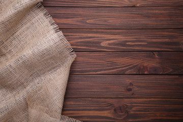 Natural sackcloth on brown wooden background. Canvas on brown wooden table