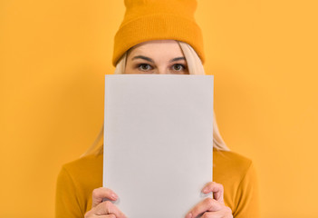 Indoor closeup monochrome portrait of of cheerful woman covers face with white book, has joyful...
