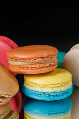Closeup of colorful pastel macaroons on black background.