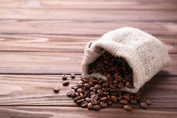 Coffee beans in burlap sack on brown table