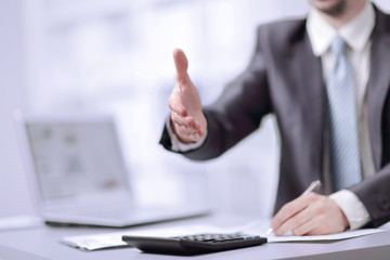close-up image of the hand of a business man in a dark suit greeting somebody