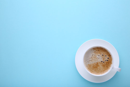 Cup of coffee on blue background, flat lay © Mouse family
