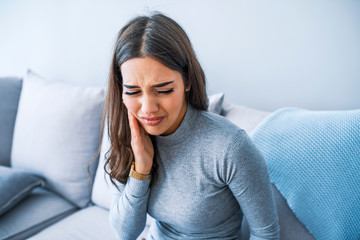 Tooth Pain And Dentistry. Beautiful Young Woman Suffering From Terrible Strong Teeth Pain, Touching Cheek With Hand. Female Feeling Painful Toothache. Dental Care And Health Concept.