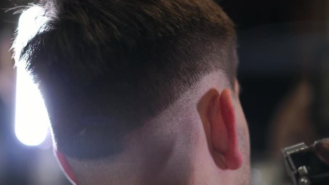 Male haircut with electric razor. Close up of hair trimmer hairstyle. Professional hairdresser cutting hair with hair clipper. Man hairdressing with electric shaver