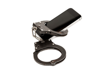 Obraz premium phone and the handcuffs. the concept of dependence on the Internet,technology and social networks. isolated on white background.