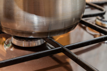 The pan is made of metal standing on a gas stove