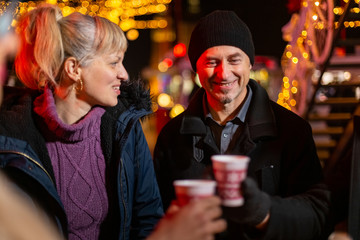 Close up image of two friends cheering at Christmas market.