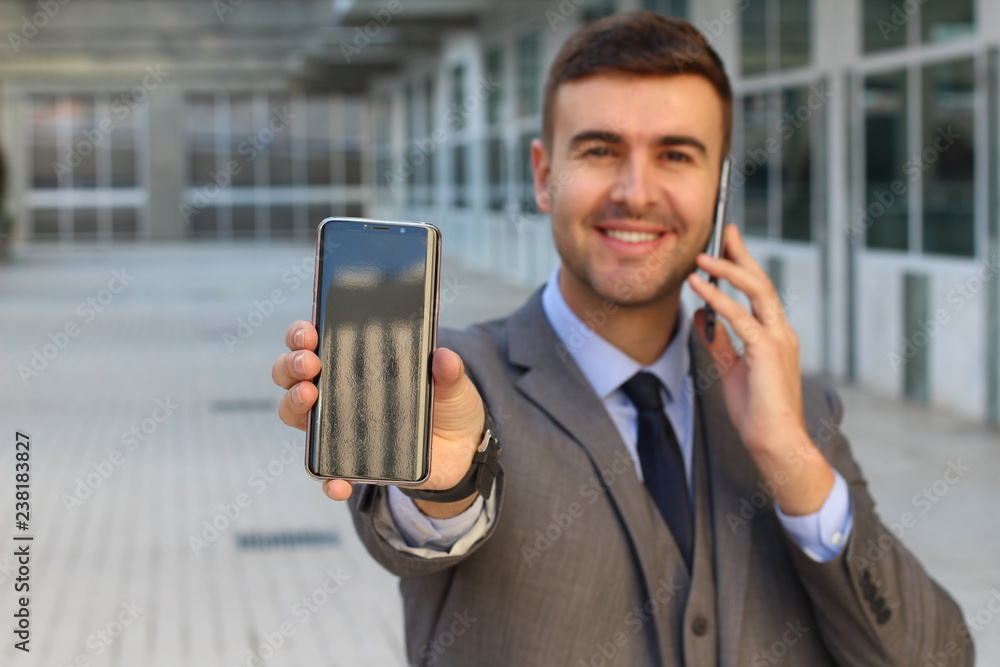 Wall mural businessman calling and showing a second cellphone screen