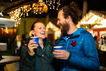 Couple enjoying traditional drink at Christmas market, Zagreb, Croatia.