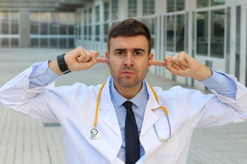Doctor blocking his ears at work