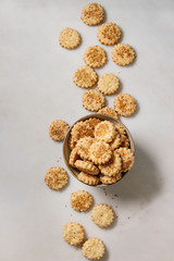Homemade snack shortbread cheese sesame cookies in bowl over white marble background. Flat lay, space