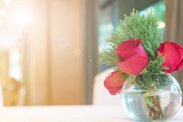 Red rose in vase on white table in hotel restuarant with copyspace