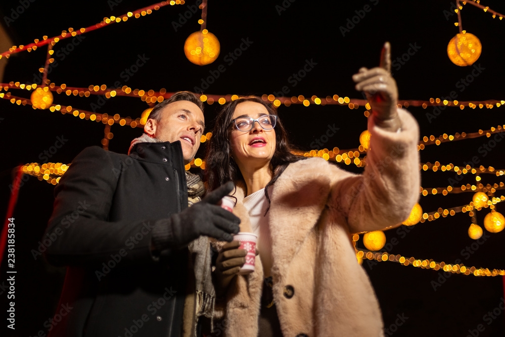 Wall mural Couple pointing to decoration at Christmas market. Zagreb, Croatia.