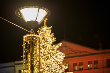 Christmas market and decorations in city center. Glowing light stripes on dark, romantic night sky background  