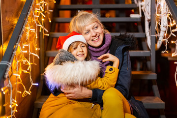 Mother hugging daughter at Christmas market, Zagreb, Croatia.