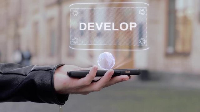 Male hands show on smartphone conceptual HUD hologram Develop. Man with the future technology mobile holographic screen on blurred background of the university