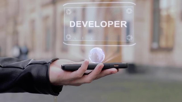 Male hands show on smartphone conceptual HUD hologram Developer. Man with the future technology mobile holographic screen on blurred background of the university