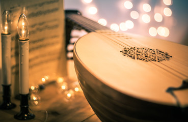 Lute with instrumental sheet music and soft lights for Christmas holiday, split tone