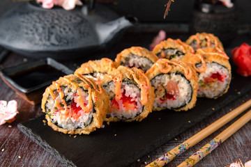 Hot fried Sushi Roll with salmon, eel, calf caviar and cheese. Sushi menu. Japanese food. Hot fried Sushi Roll