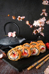 Hot fried Sushi Roll with salmon, eel, calf caviar and cheese. Sushi menu. Japanese food. Hot fried Sushi Roll