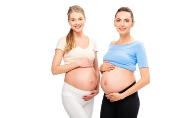 two pregnant women showing bellies turned to each other isolated on white
