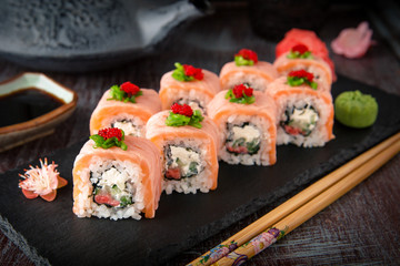 Philadelphia roll sushi with salmon, cucumber, avocado, cream cheese, tobiko caviar. Sushi menu. Japanese food. 