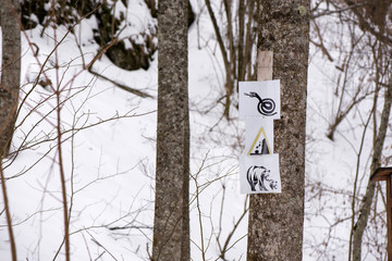 White warning signs of falling rocks, snakes and bears possible to meet in mountain valley hiking trails. Dangerous environment. Concept of wild animals, adrenaline and looking for adventures. 