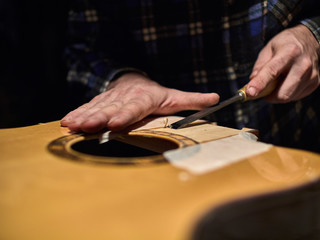 Fastening the neck to the Soundboard of the guitar. Removing the varnish from the Soundboard.