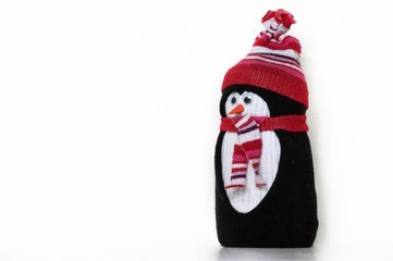 Cute penguin toy, made of white, black and colorful socks, with hat and scarf, textile figure. Handmade home winter decoration. Do it yourself. White background, copy space for text.