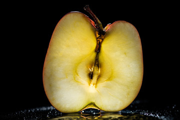 half of ripe apple on black background
