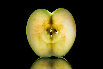 half of raw ripe apple isolated on black
