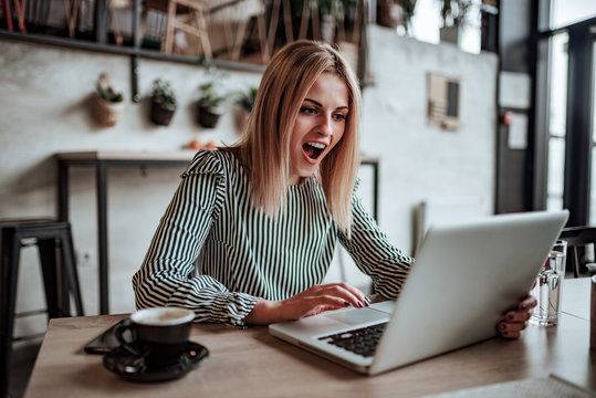 Positive Surprised Young Woman Looking At Laptop Screen.