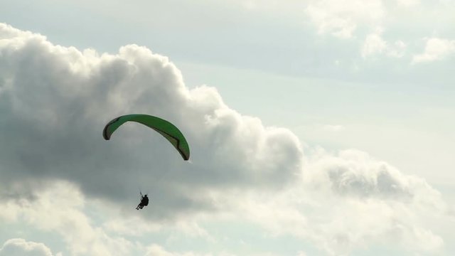 the paraglider flies on a background of a cloudy sky