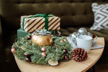Decorative houseplants in winter. Florarium with fresh flowers on the table in a bright living room, decorated for Christmas.