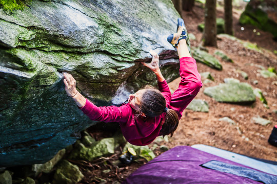 Young female athlete climbing outdoor on a stone