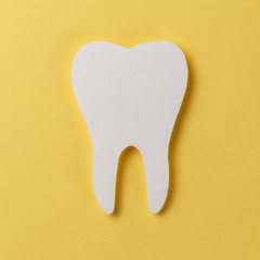 White tooth on yellow background. Oral dental hygiene. Teeth whitening. Dental health concept. Oral...