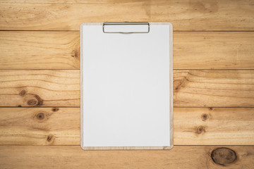 Mock up clip board and white paper on wood background.