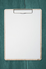 Mock up clip board and white paper on wood background.