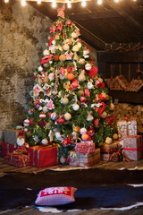 Obraz na płótnie Canvas Red-brown Christmas attic interior with Christmas tree, fireplace, gifts.