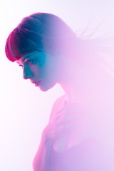 Moody cinematic portrait of ginger caucasian woman with blue eyes on fuchsia and blue light and white background,prism reflections