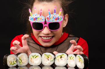 funny young girl in birthday with sushi rolls