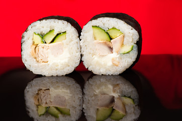 two beautiful fresh sushi rolls in reflection 