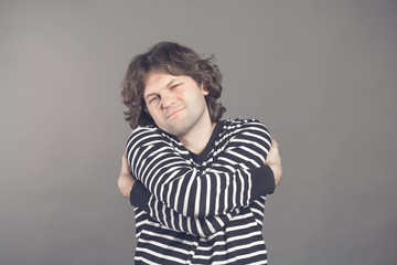 You do not need girlfriend if you can hug yourself. Concept of selfish feeling. Funny caucasian guy in white shirt cuddling himself and smiling from pleasure, closing eyes